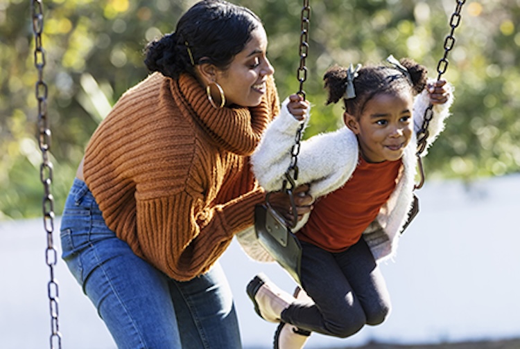 Mom and child playing on a swing