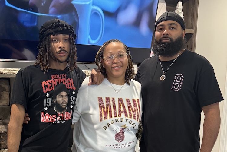 Son standing with mother and father in a cafe
