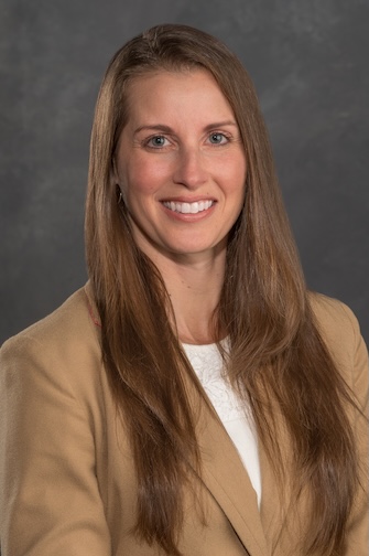 Headshot of Lana Sargent wearing a tan suit.