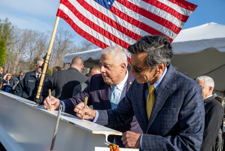 Dr. Levy and President Rao signing construction beam