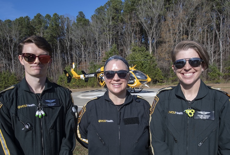 Members of VCU Health LifeEvac emergency aviation team stand near a helicopter.