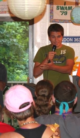 Teenage boy speaks to a group of other campers