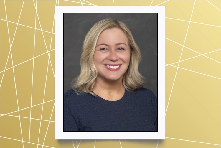 Sinclair is smiling as she wears a navy shirt