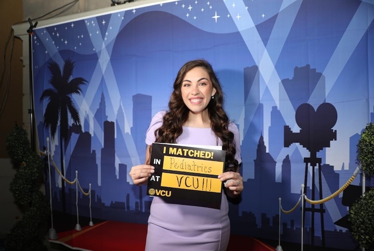 Woman holds sign smiling