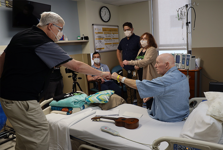 Michael Stigall  in a hospital room with his loved ones and clinicians, a doctor is shaking his hand.