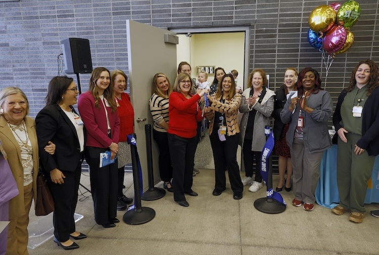 Team member gathered around the enterance for the ribbon cutting
