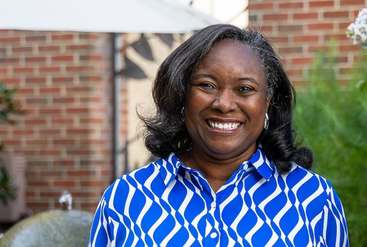 Dr. Baskin smiles while wearing a blue and white shirt outdoors