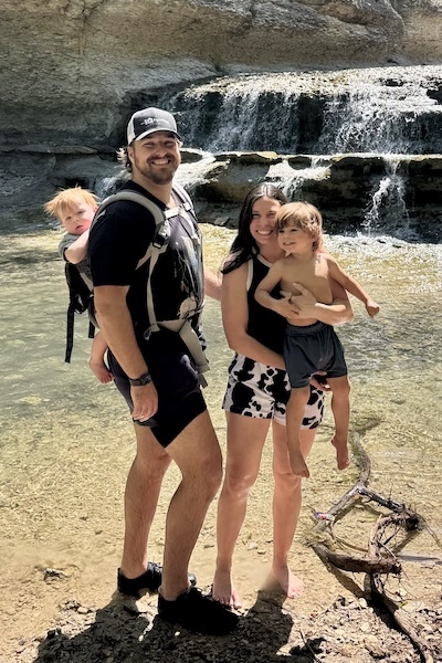Burn survivor and his family stand near a waterfall