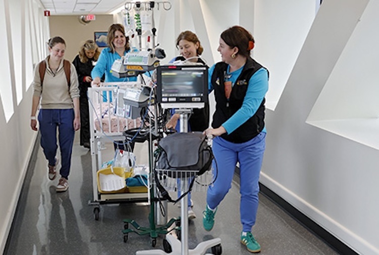 CHoR team members are in a hallway transporting a NICU patient to the new space.