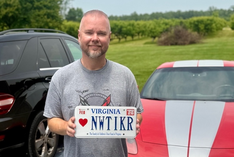 Brian holds up the license plate for his new Corvette.