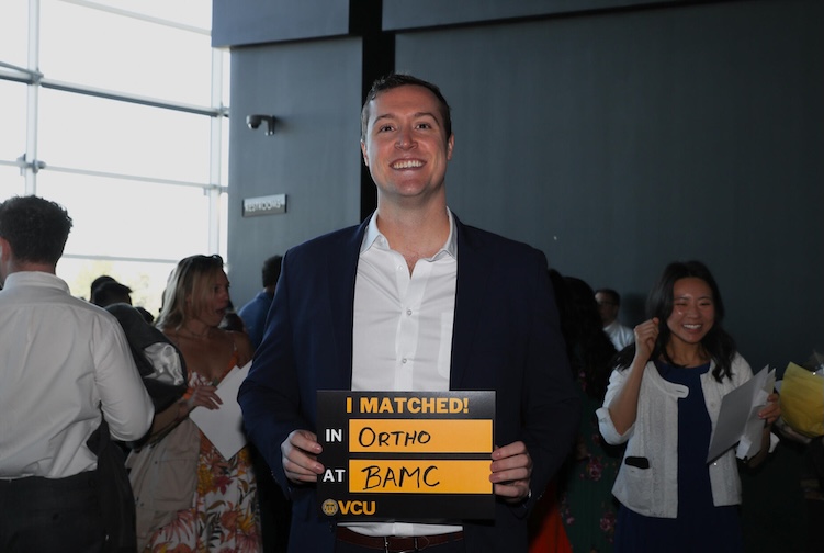 Nathan Swift holding VCU Matched sign