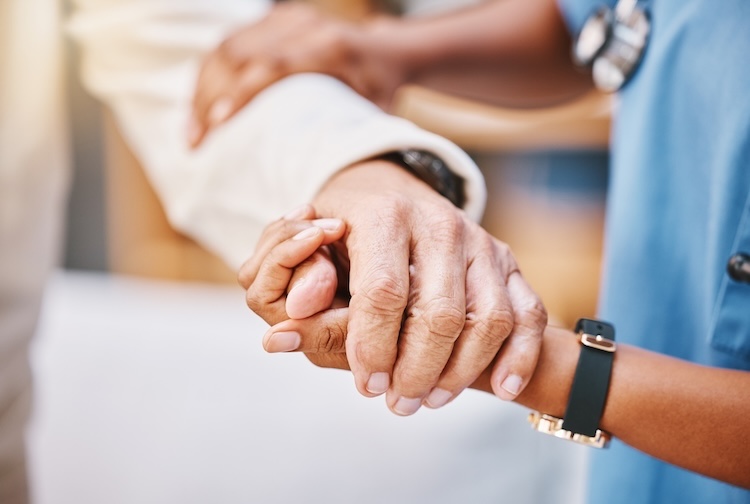 Nurse’s hands and helping patient with walking.