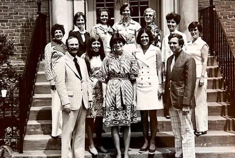 Black and white photo of a group of nurse practitioners standing outside on steps of a building.