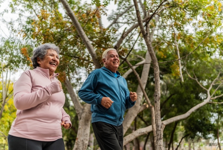 Older couple talking and running in a public park