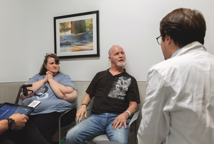 Parkinson’s patient and his wife sit and talk to their VCU Health doctor
