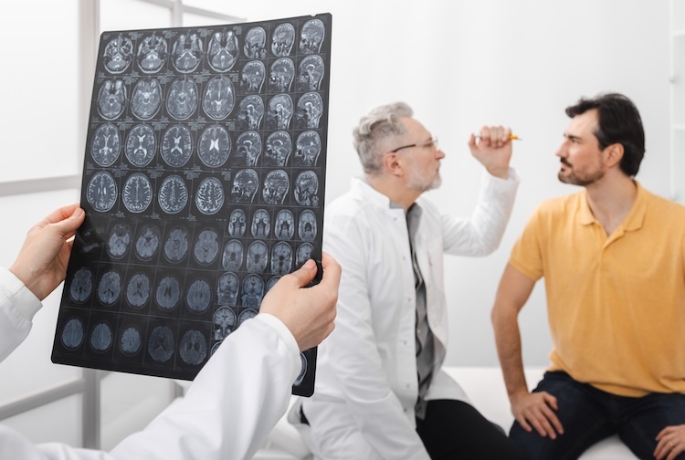 Male patient underwent MRI of brain and is consulting with hospital neurologist doctor.