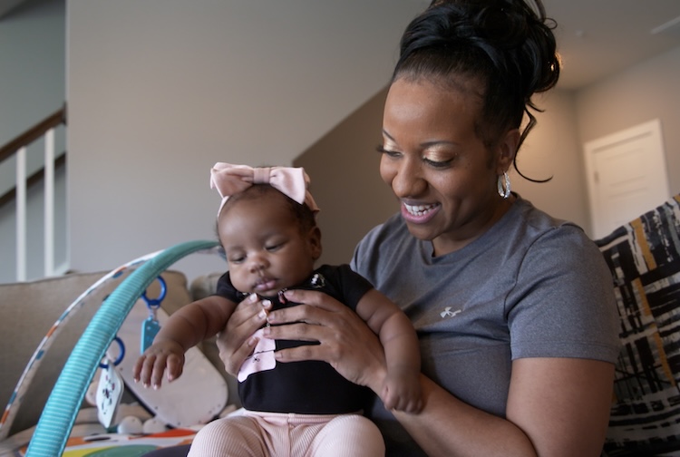 Precious Wilson holds baby daughter in their home