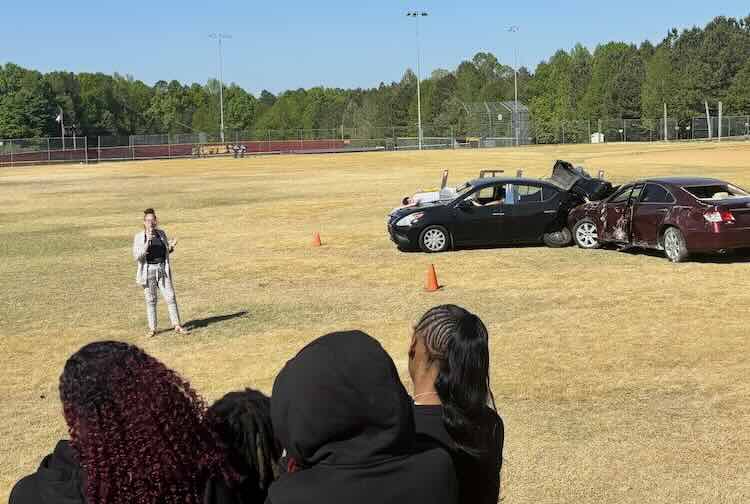 A hospital volunteer speaks to high school students about the risks and consequences of impaired driving.