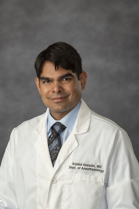 Dr. Hussain in his VCU Health white coat.