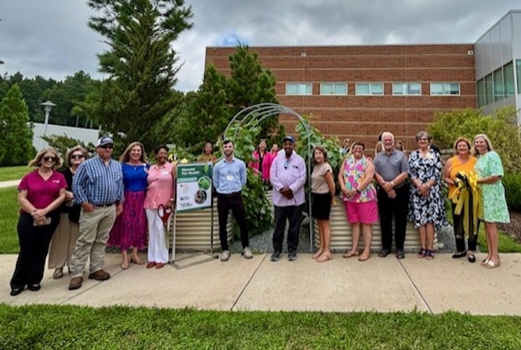 Group poses after ribbon cutting for new community garden