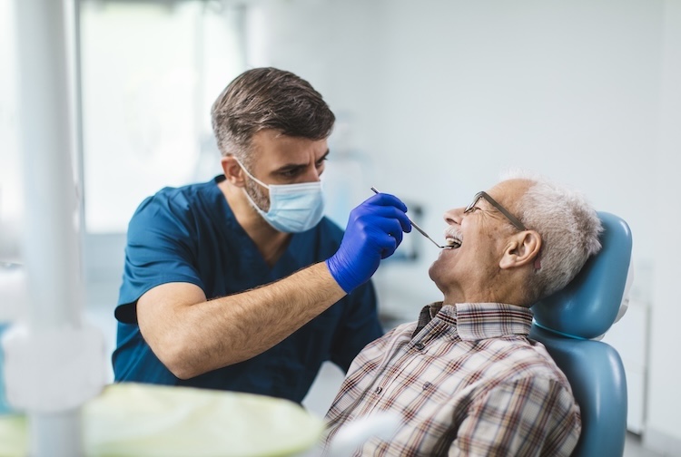 Young dentist giving his senior patient a routine checkup