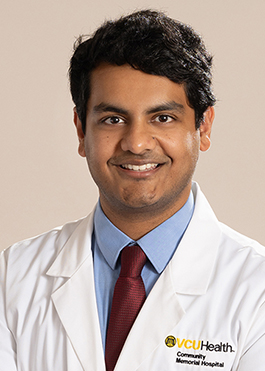 Dr. Raghu Rudraraju in a white medical coat