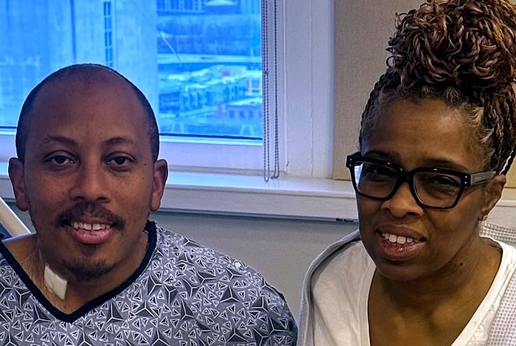 Living liver donor Marcus and liver transplant recipient Stephanie wearing hospital gowns and smiling at VCU Medical Center.