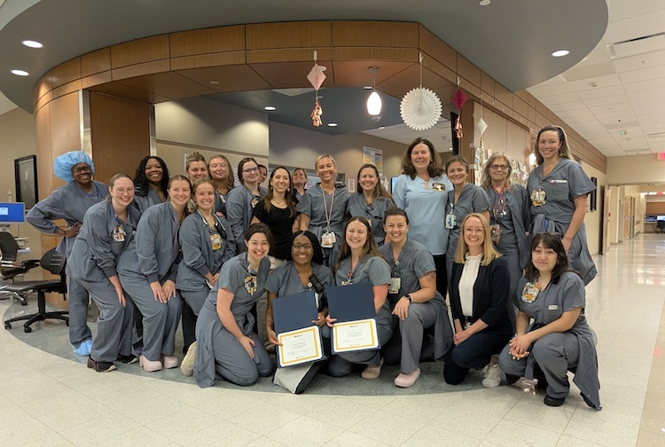 Labor and delivery team pose together in hospital hallway