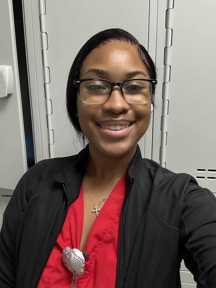 Sherilya smiles in professional business attire