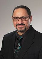 Dr. Manhal Saleeby in a black suit