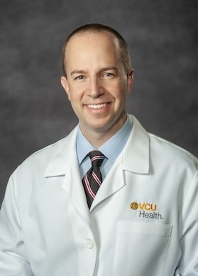 Dr. Cheatham wears his white medical coat