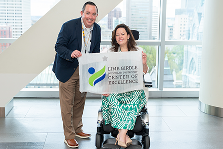 Doctor and vcu health patient hold up a sign for the LGMD Centers of Excellence