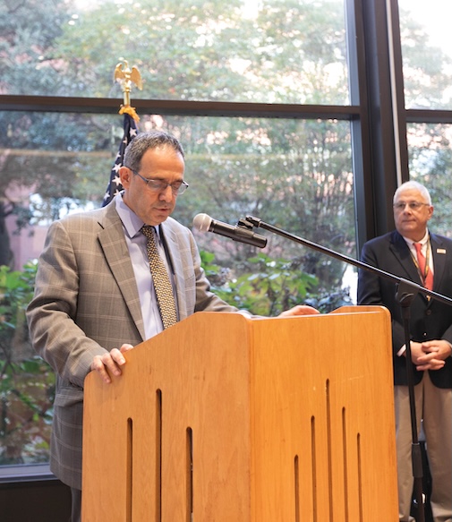 Man standing at podium speaking to a group