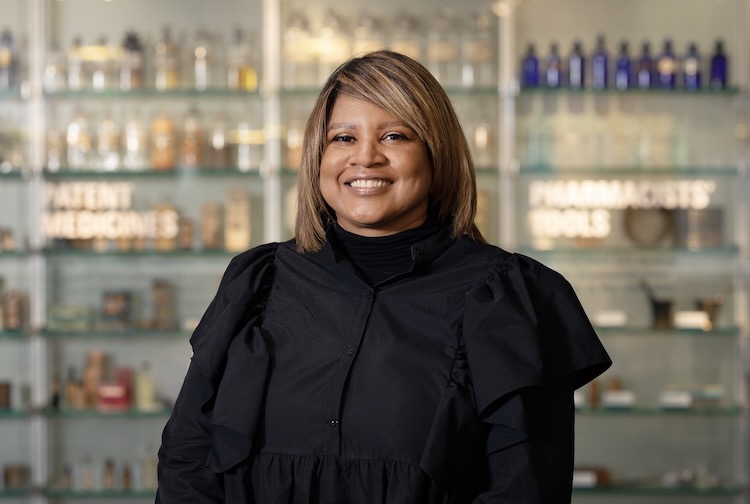 Erika Nixon-Lambert in all black sitting in a lab.