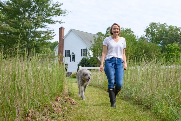 Breast cancer survivor smiles while walking around her farm with dog