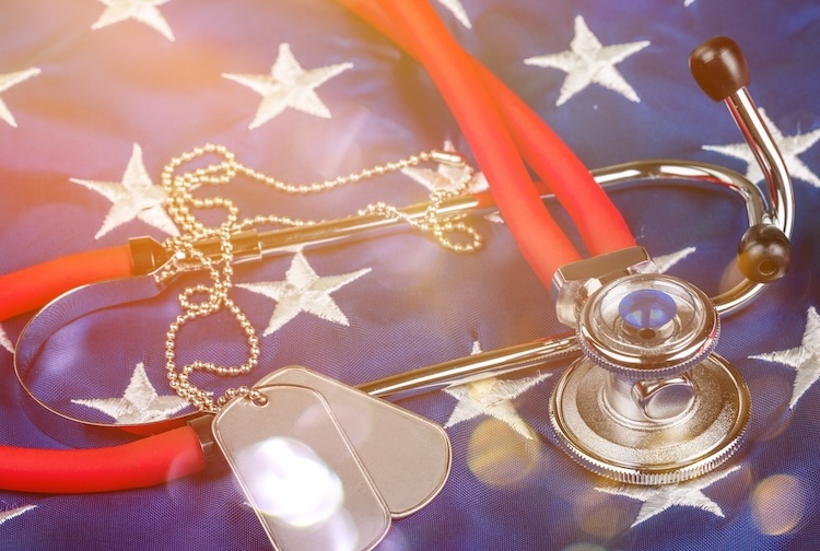 Blank dog tags and a stethoscope laid out on an American flag