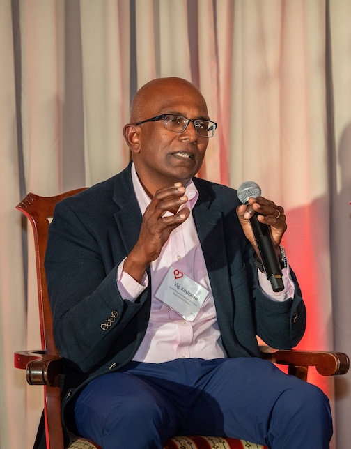 man sitting in a suit holding a microphone