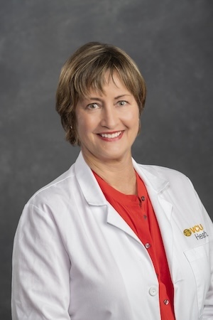 Nurse Krebs wears a red shirt under her white medical coat