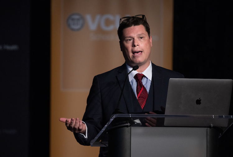 Albert Arias, M.D., presenting his research results from a podium at the inaugural academic symposium of the Stravitz-Sanyal Institute for Liver Disease and Metabolic Health at VCU. 