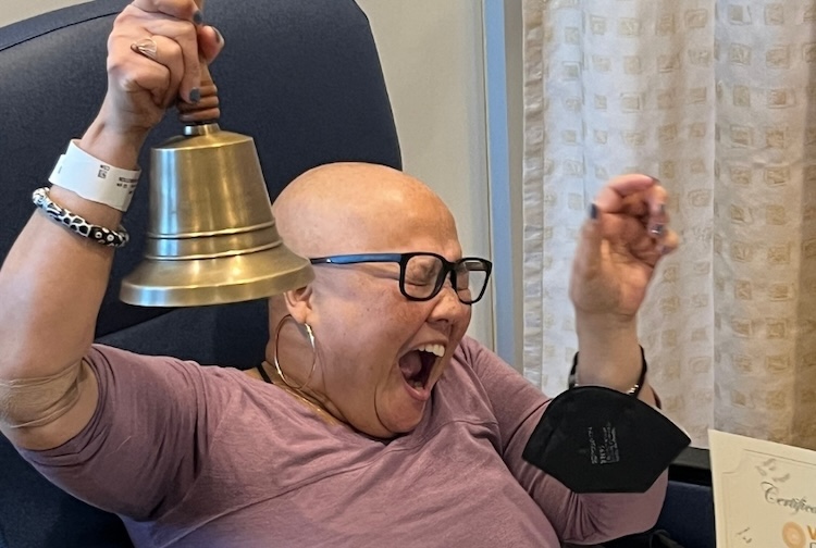 Women sitting in chair, rings bells 
