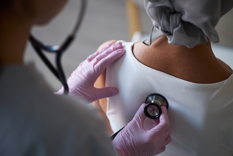 Female doctor examines the heart of a female cancer patient