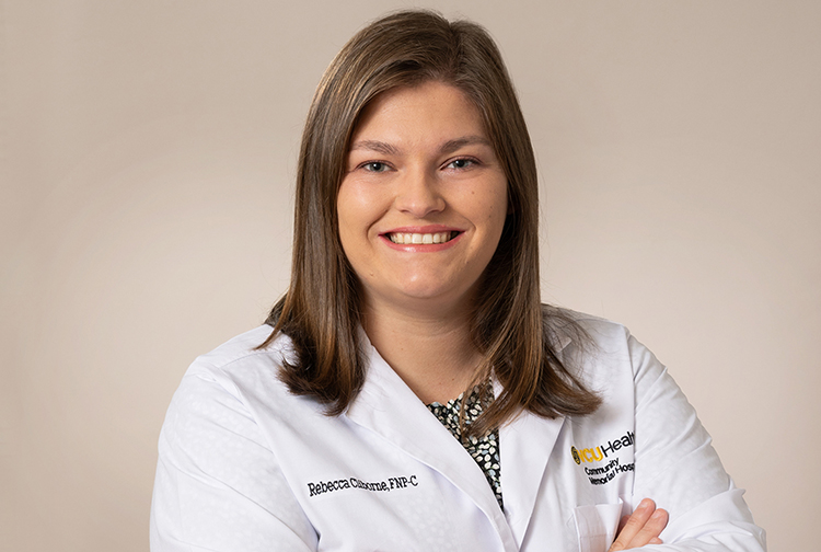 A lady in a white lab coat smiles.