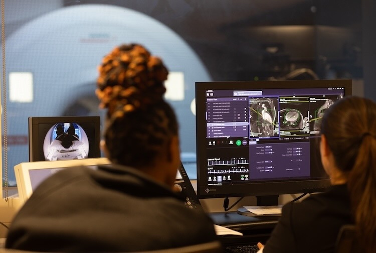Two people look at the scans of a person’s heart after a stress test in the MRI.