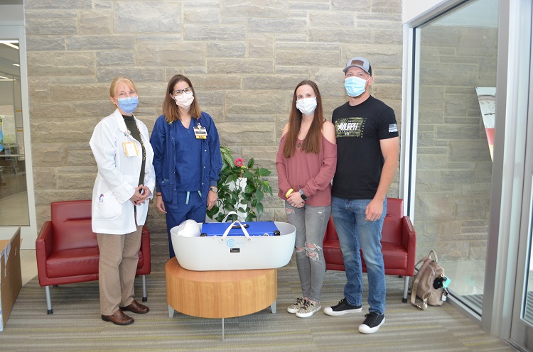 Robby and Haley Emerson standing with CMH team members next to donated CuddleCot