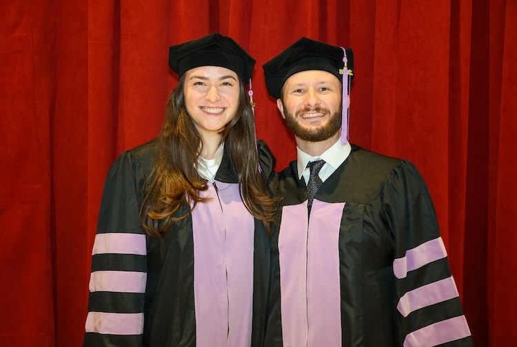 Two dentists in their graduation caps and gowns