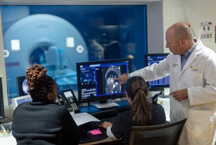 Clinical team in the control room reviewing scans of a patient’s exercise stress test