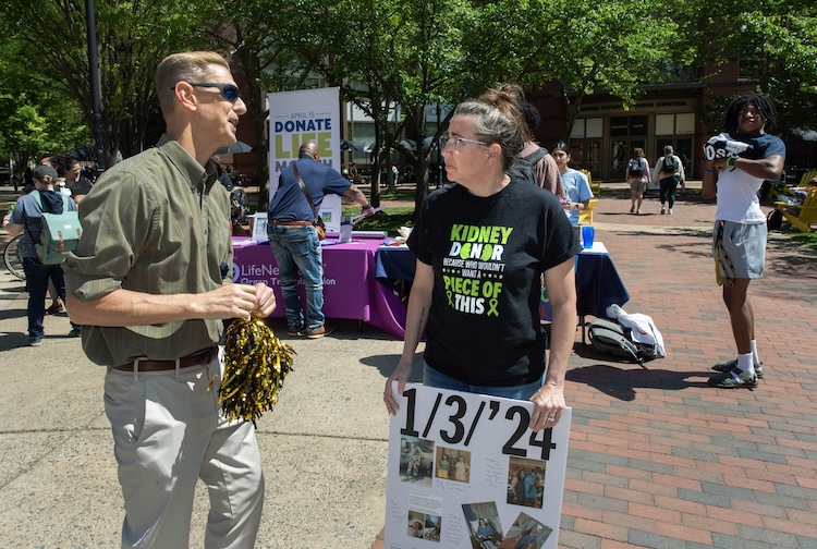 Two people standing outside with Donate Life signs