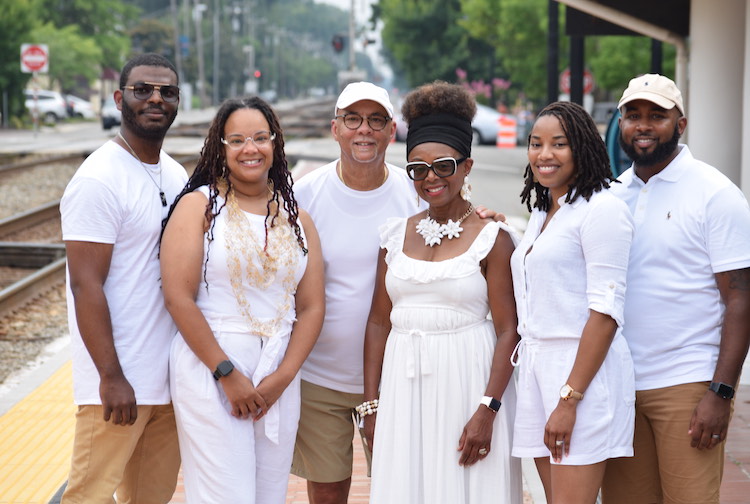 Family photo of the Easters. Everyone is dressed in white and are posing. 