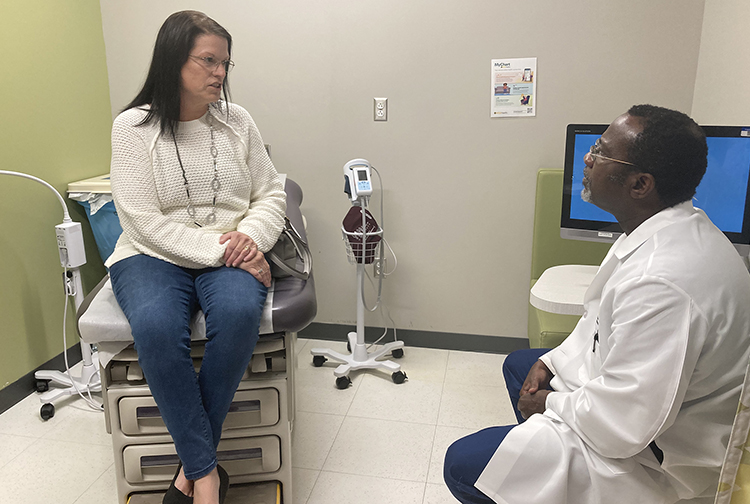 A patient meets with a doctor in an exam room.
