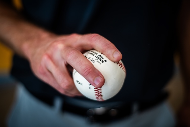 Dr. Brett Goodloe holds a baseball as if about to pitch.